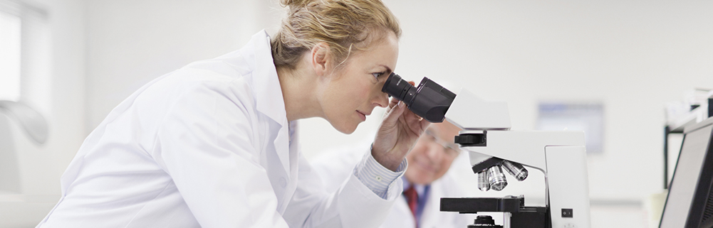 Female researcher looking through microscope