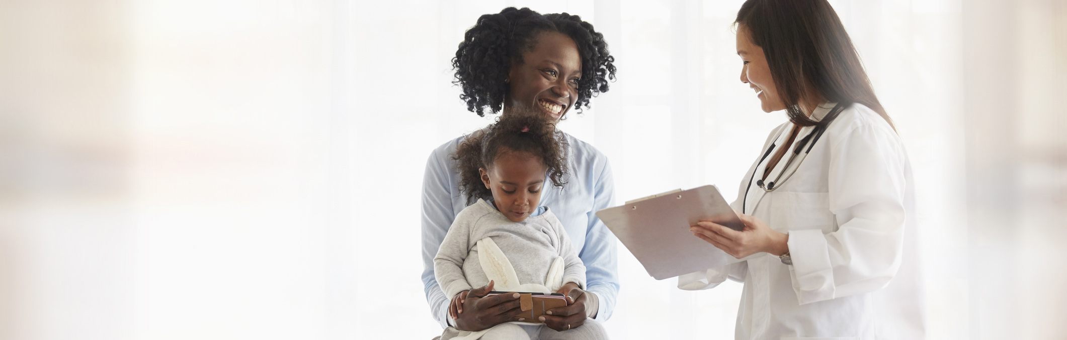 Mother talks to a pediatrician with daughter on her lap