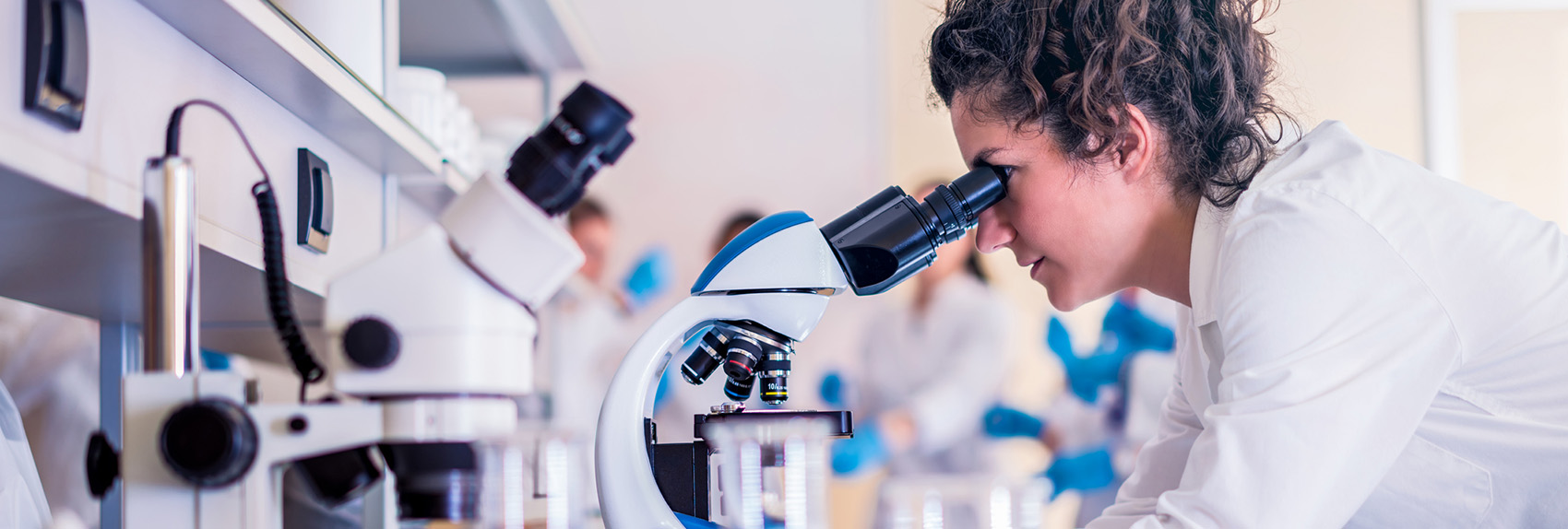 Female scientist looking through a microscope