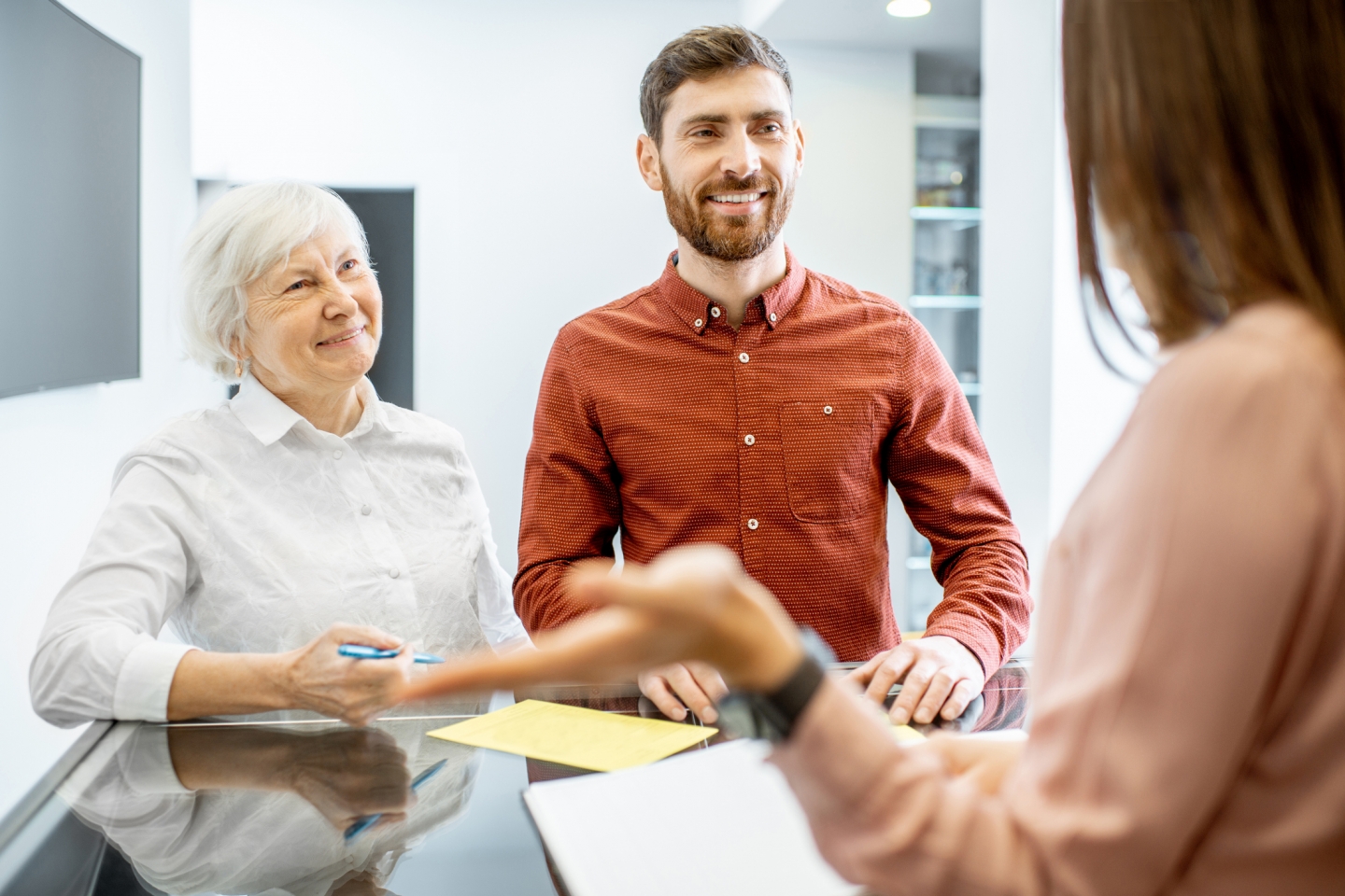 Older woman with adult son talking to doctor