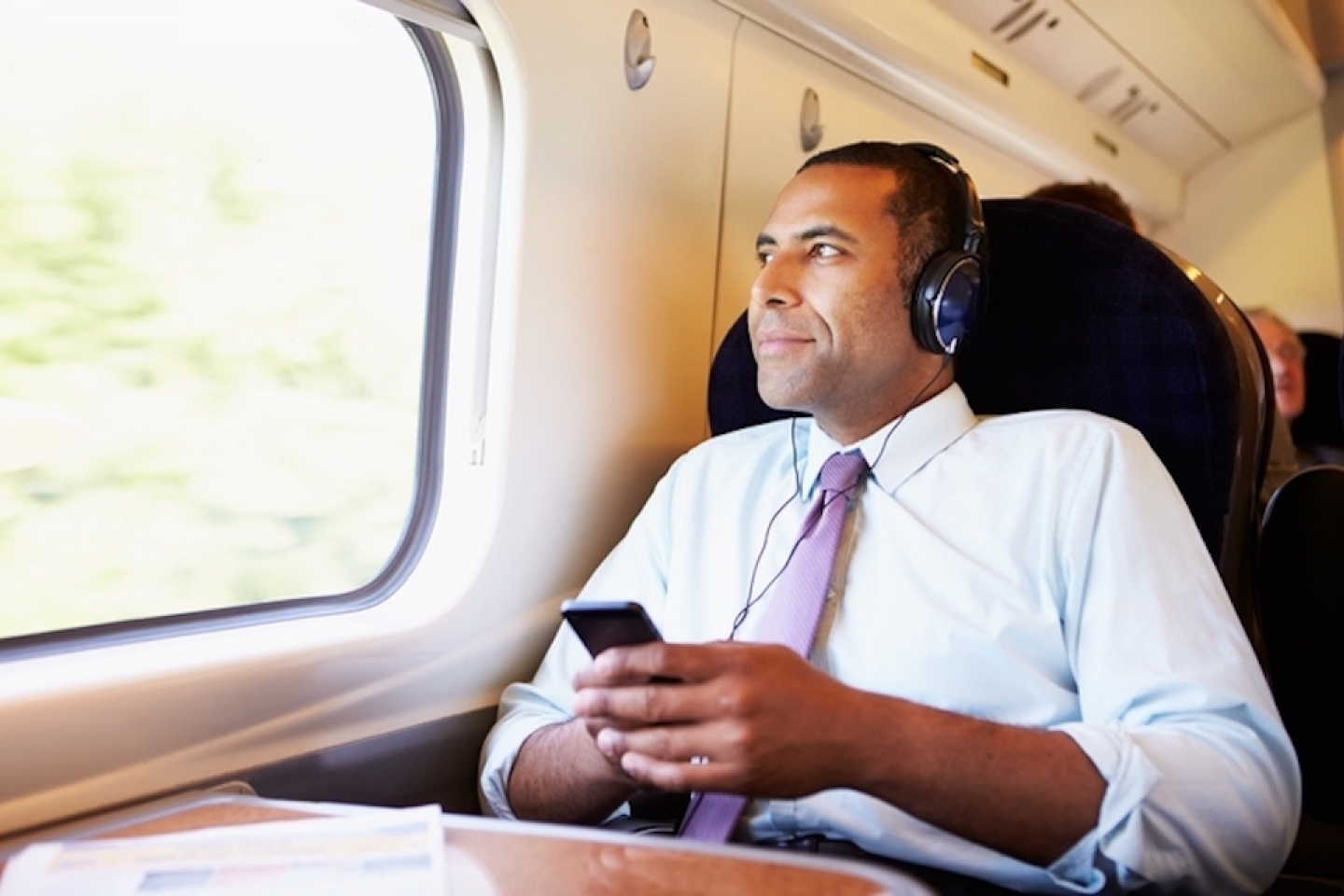 man wearing headphones while listening to podcast on phone
