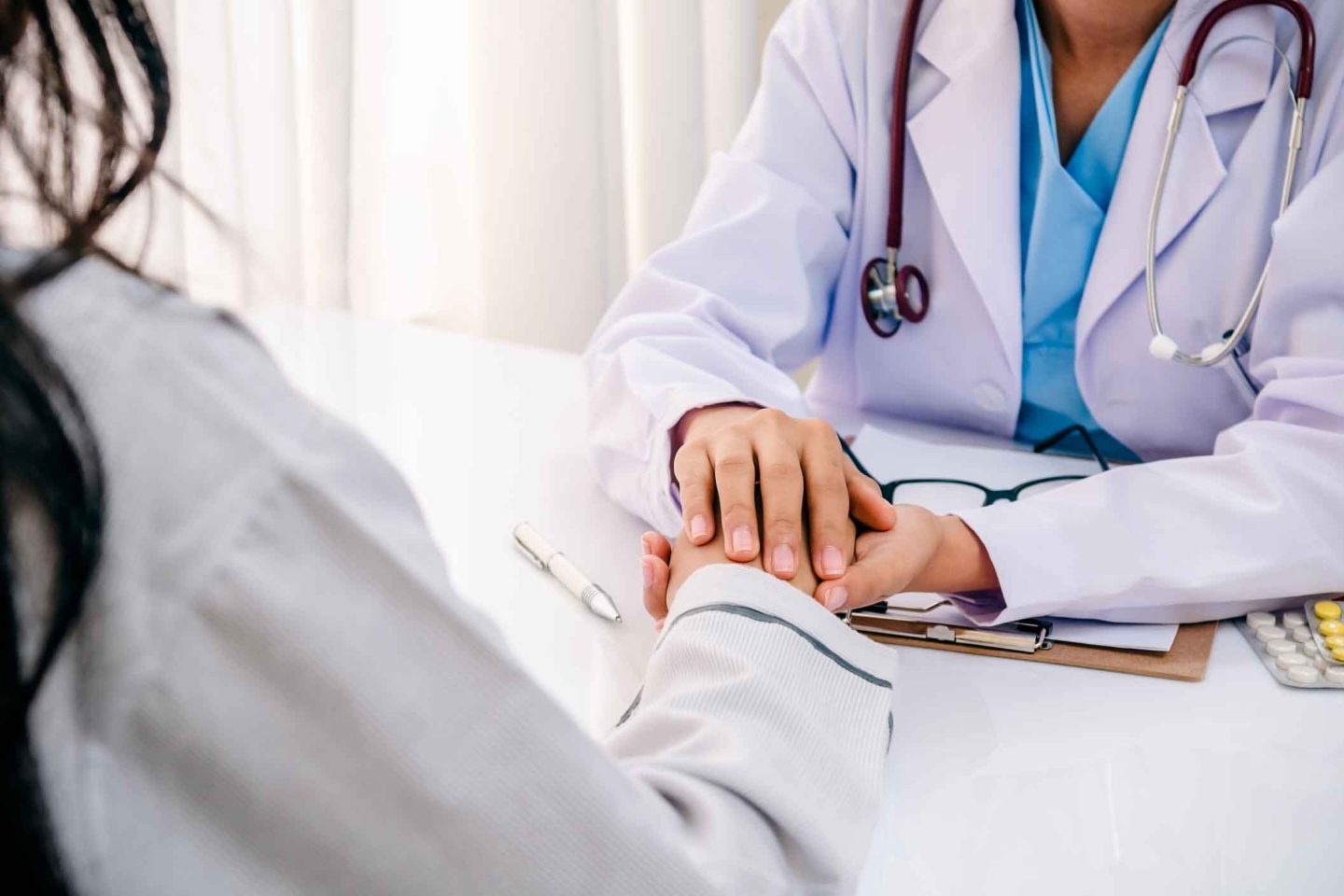 close-up of doctor holding woman's hand