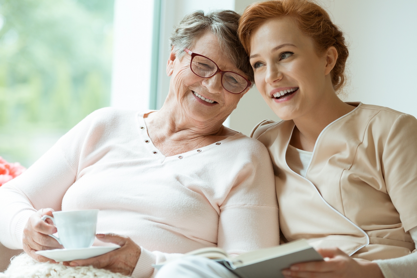 Caregiver and woman sitting at home.