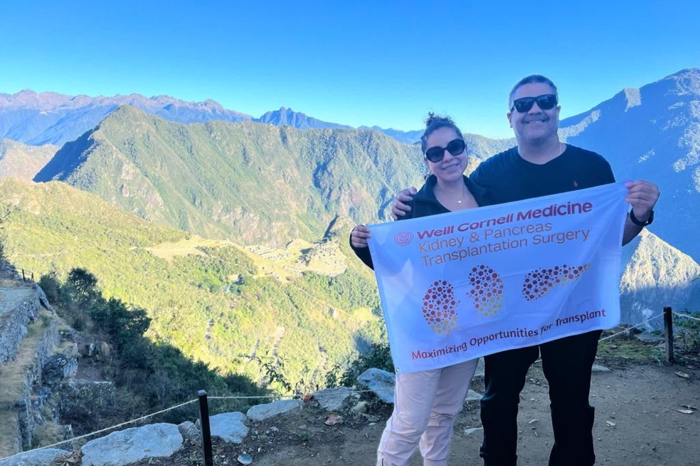 Hector Sanchez climbs Machu Picchu and holds weill cornell medicine flag