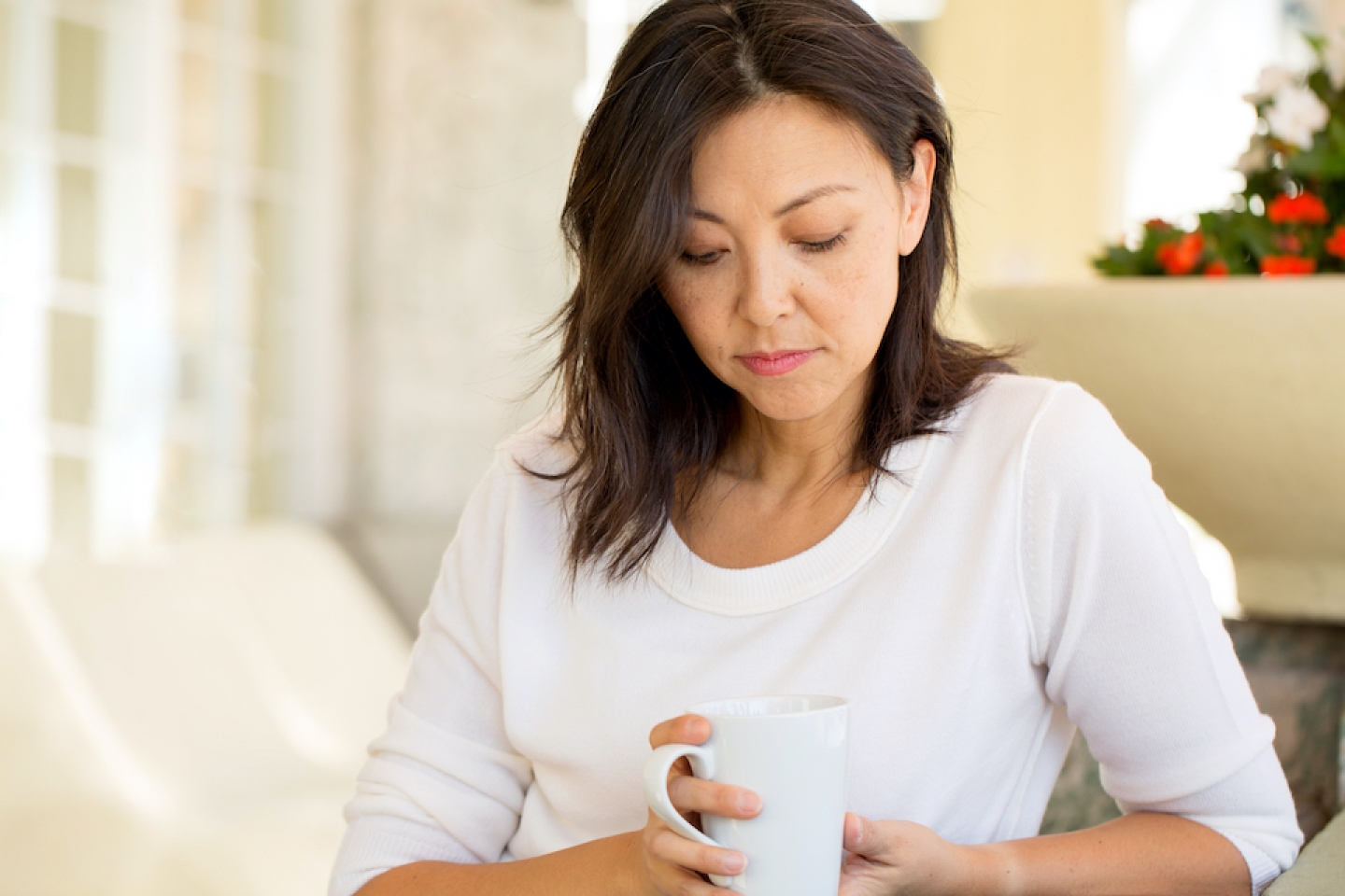 woman looks down at cup