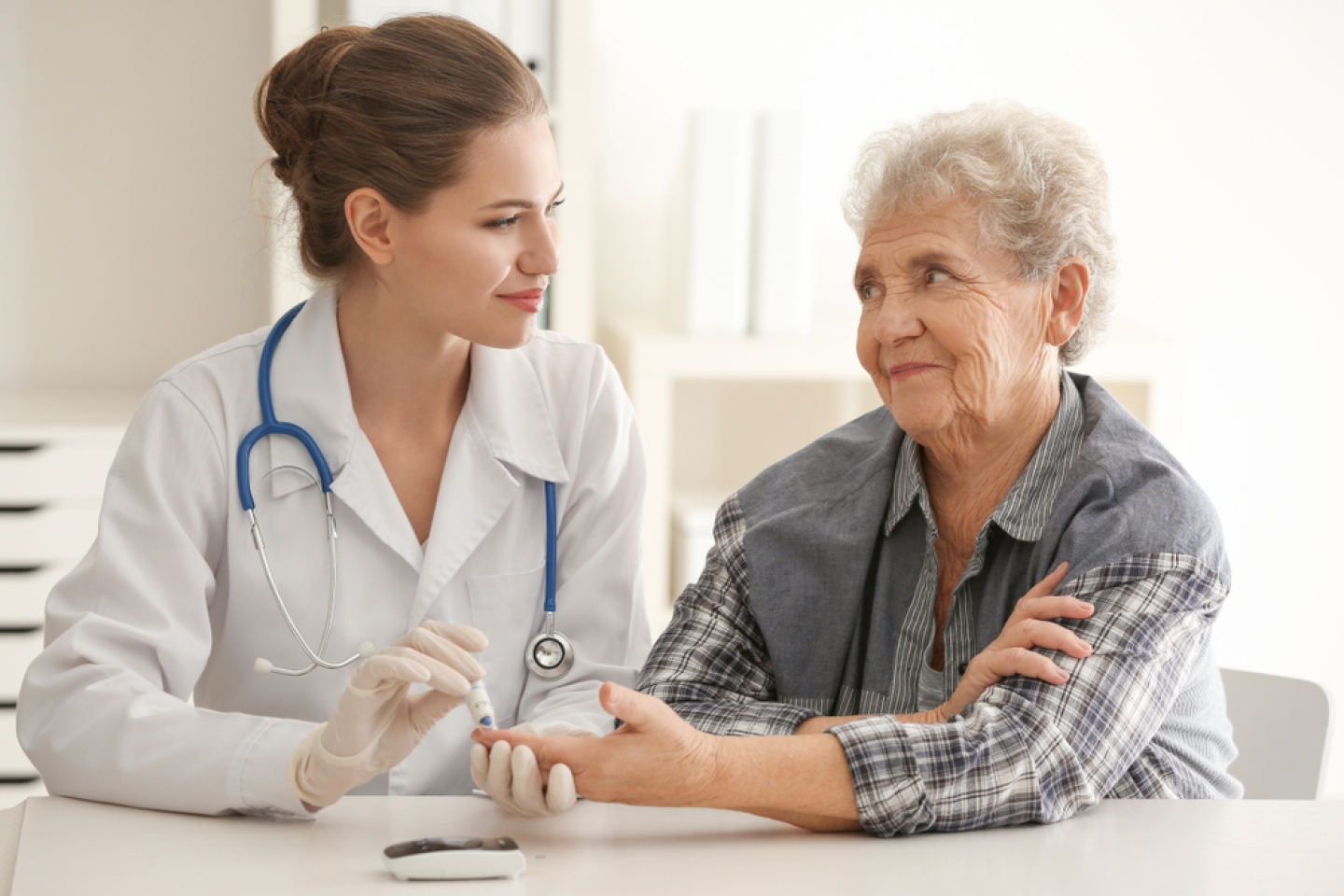 Doctor measuring blood sugar level of diabetic patient in clinic