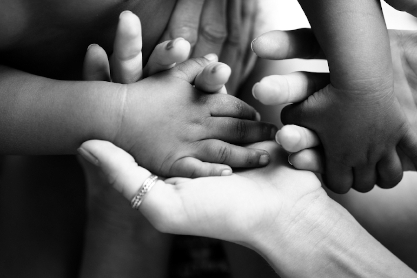 black white photo of family holding baby's hand