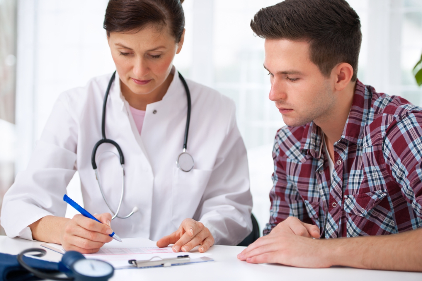 doctor talking to her male patient at office