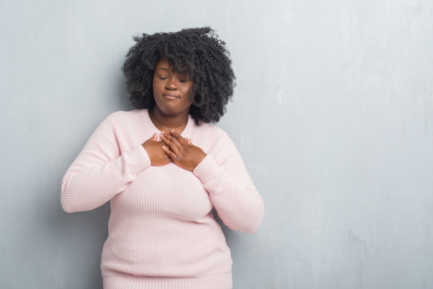 black woman holding hand over her heart