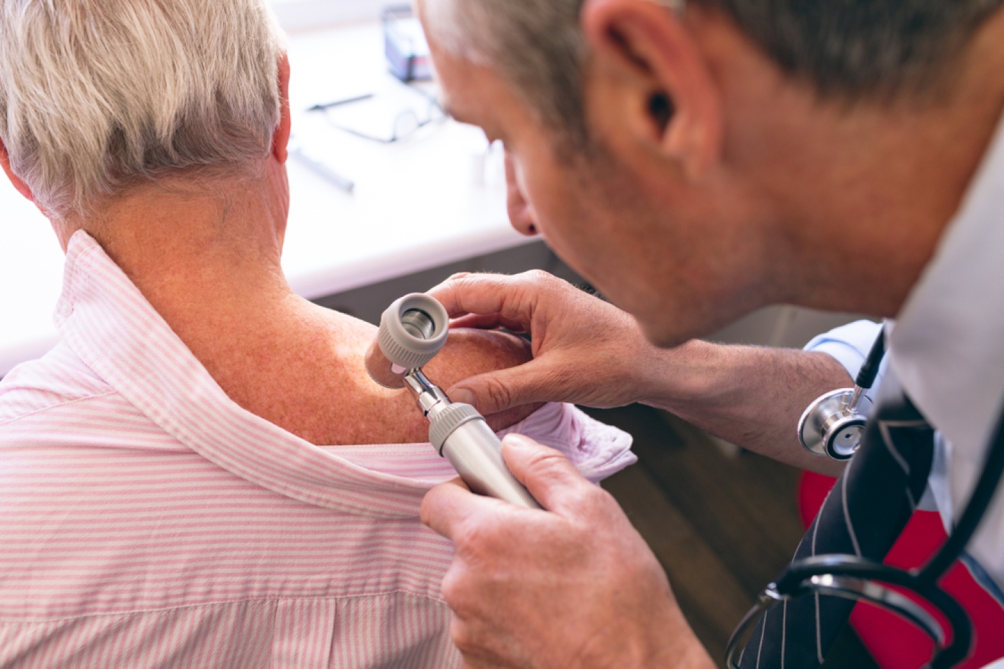 doctor inspecting patient's skin