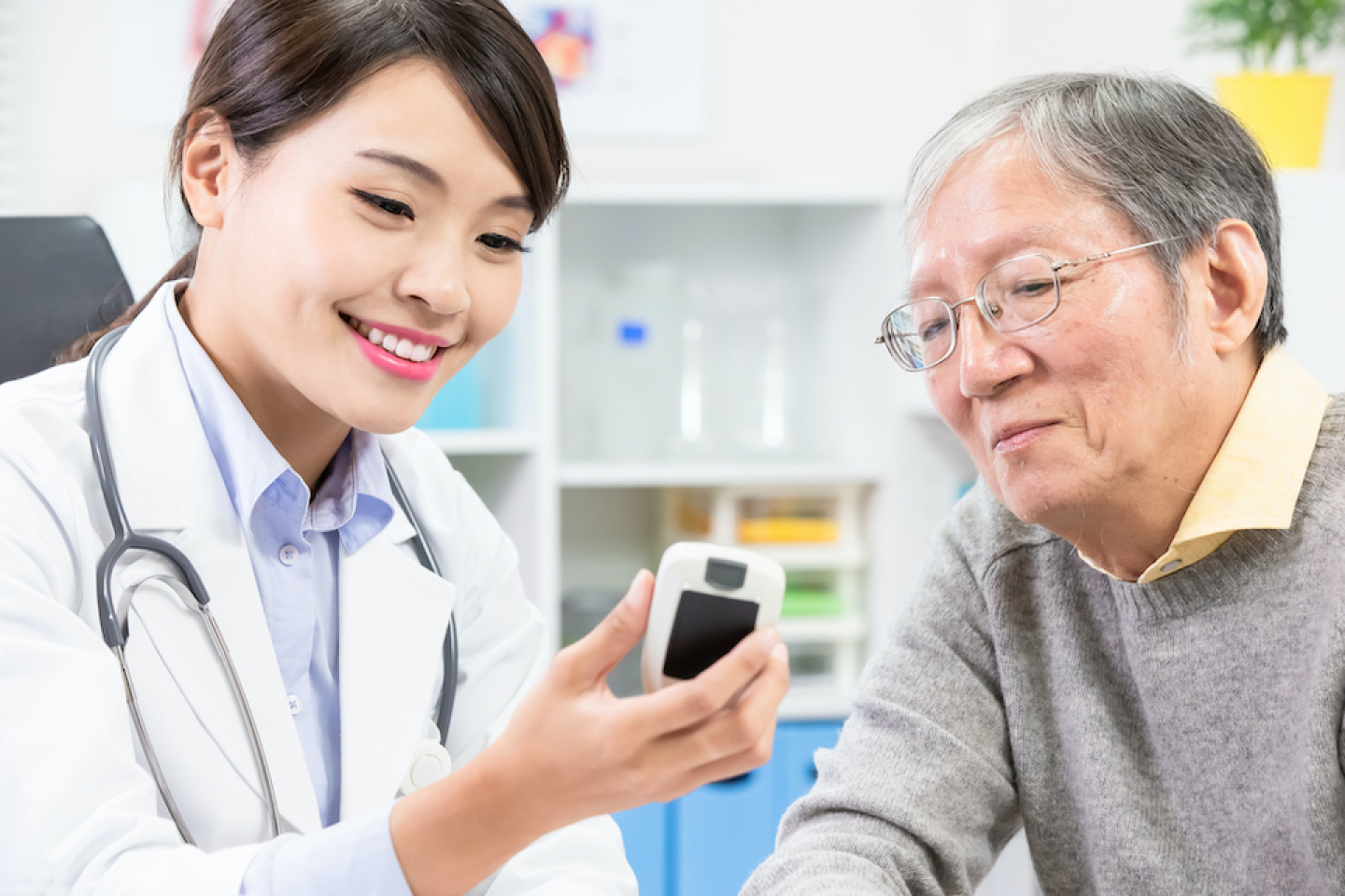 Doctor and patient looking at Glucose monitor reading