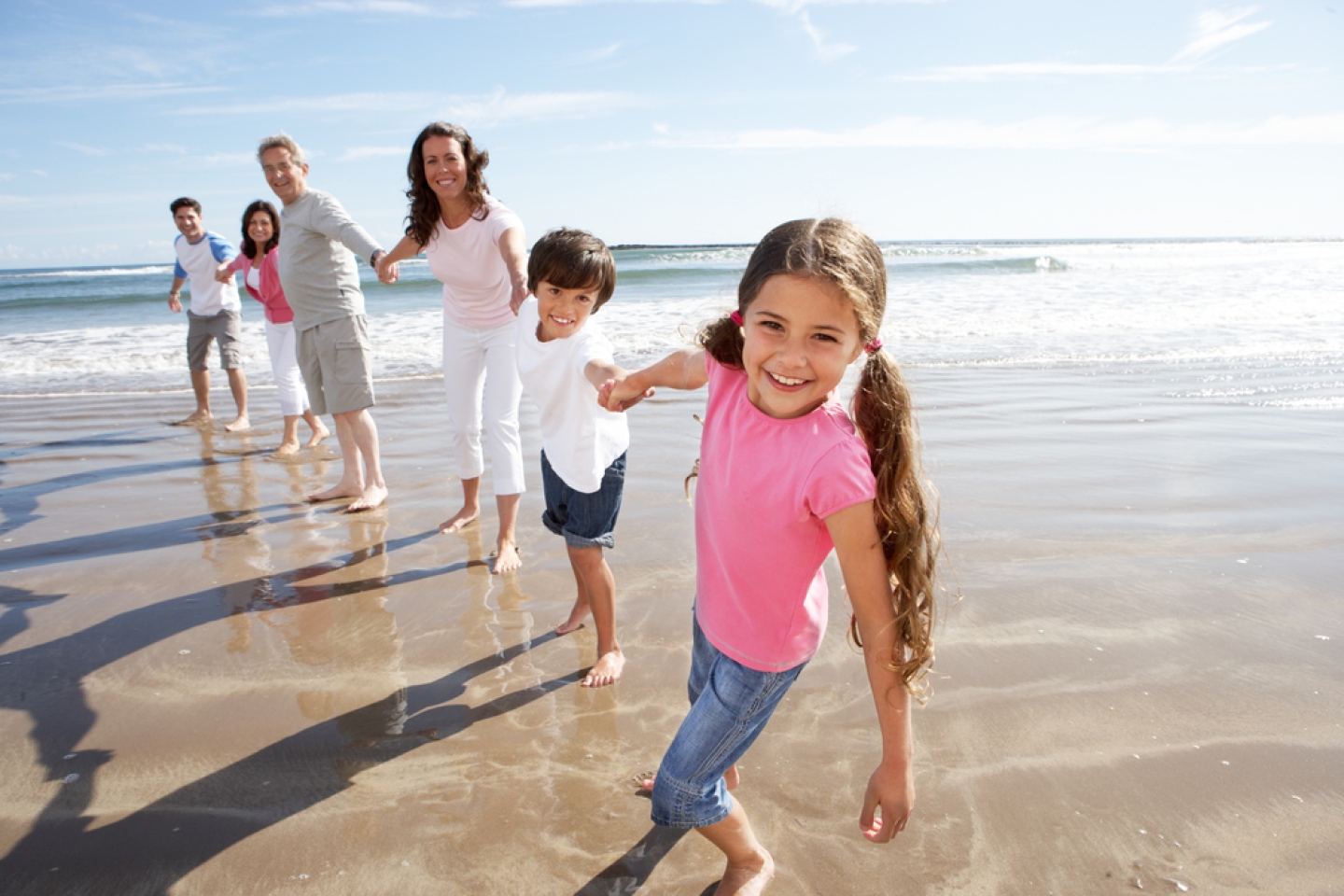 Multi Generation Family Having Fun On Beach Holiday