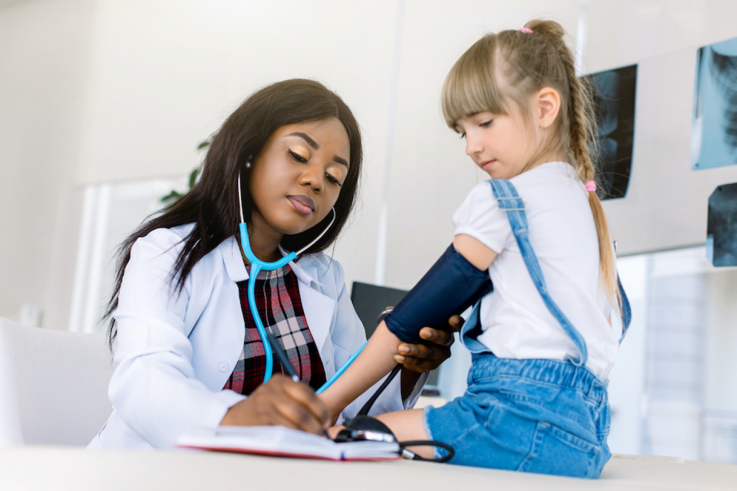 doctor checks young patient's blood pressure