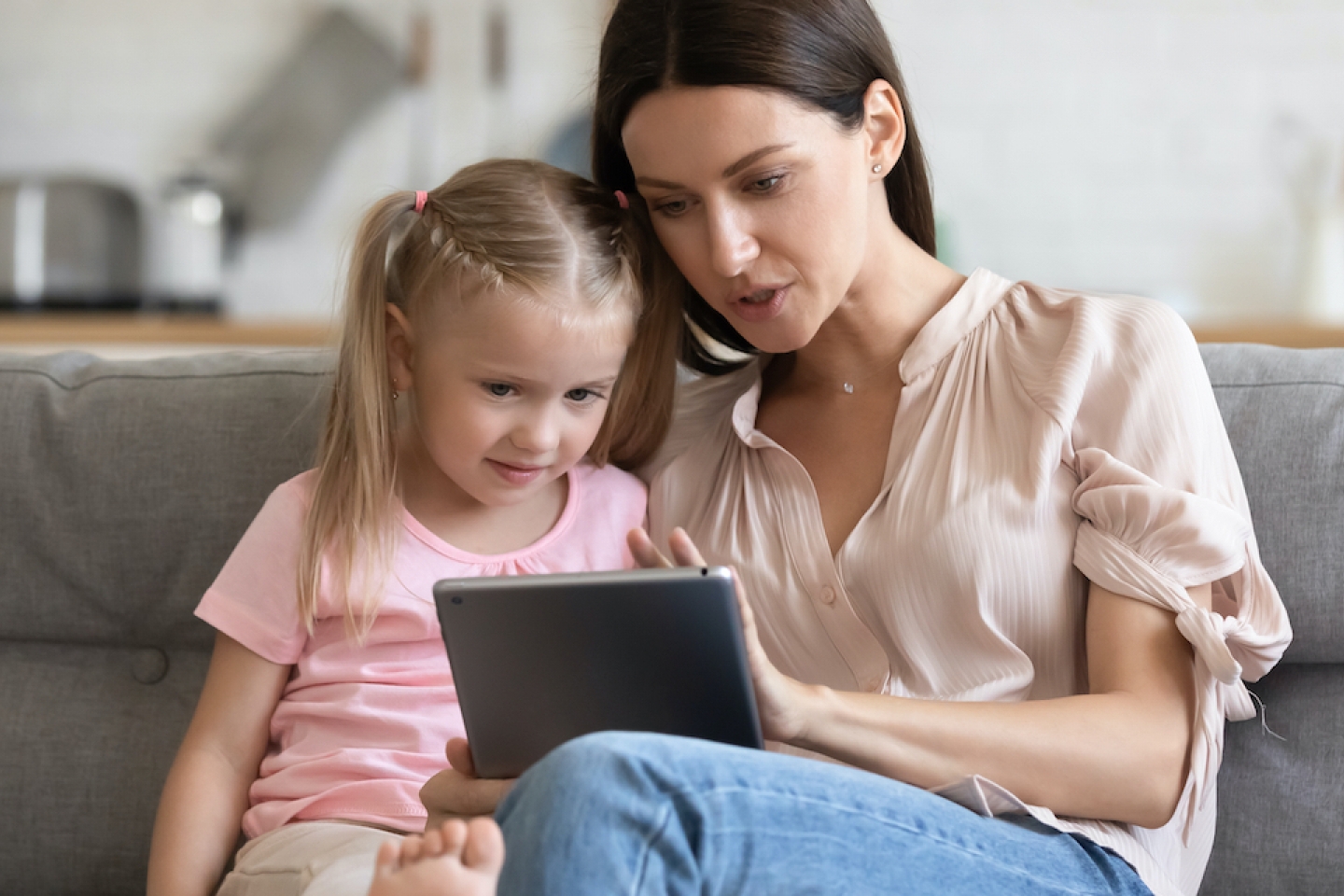 mom with her daughter looking at a tablet