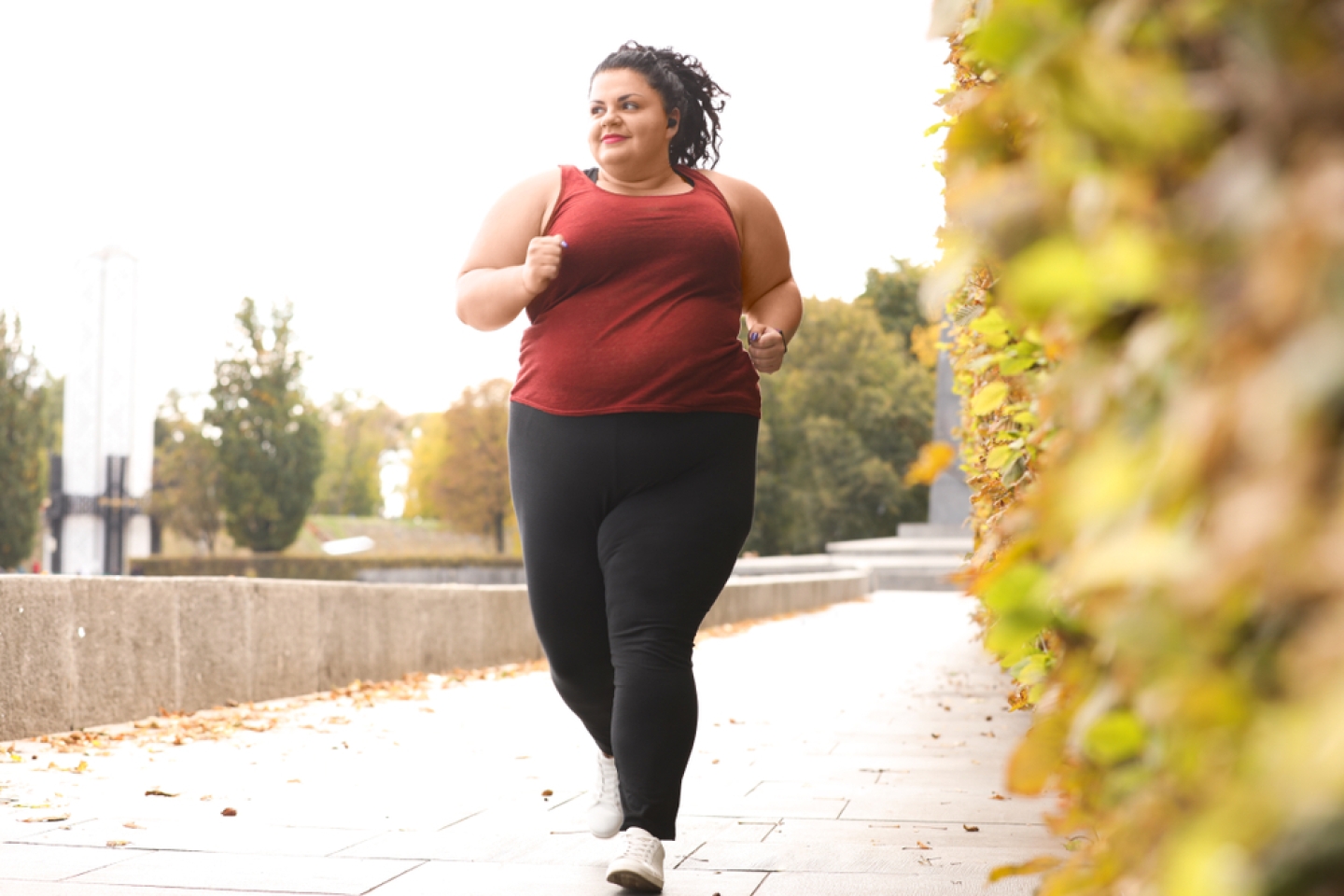 Beautiful overweight woman running in park. 