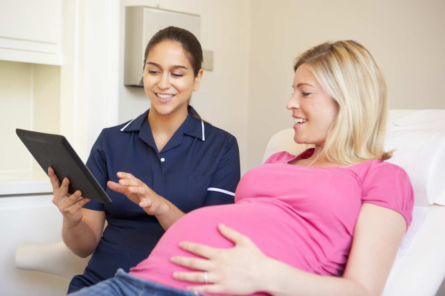 pregnant adult speaks with nurse