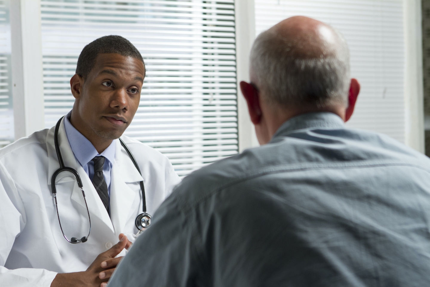 black male doctor meets with older male patient