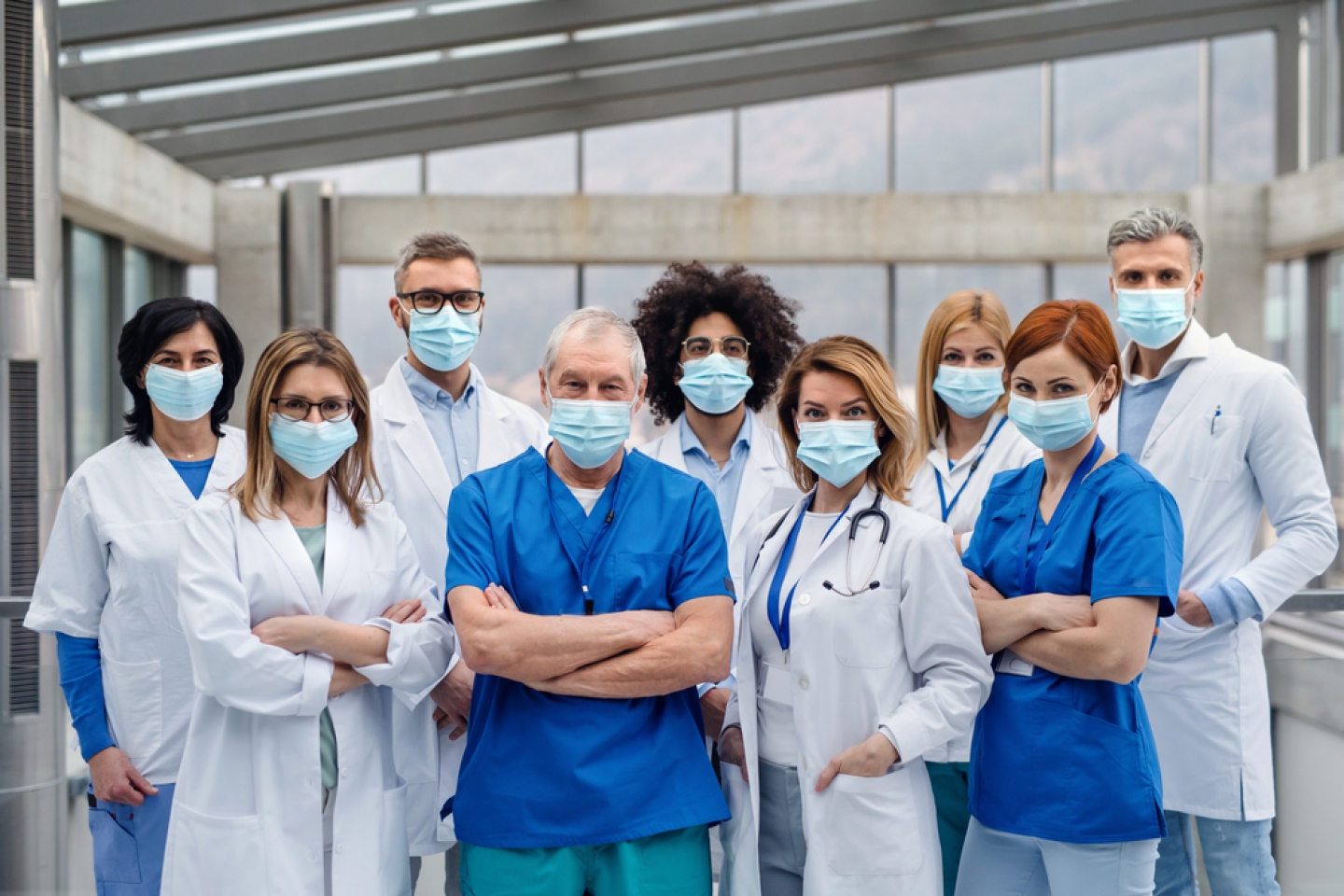 Group of doctors with face masks looking at camera, corona virus concept.