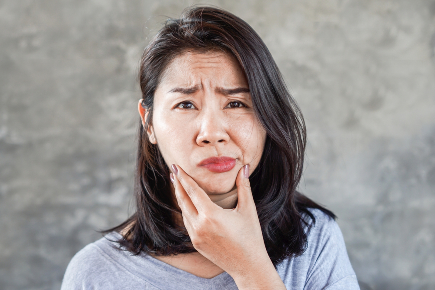 Asian woman hand holding her face