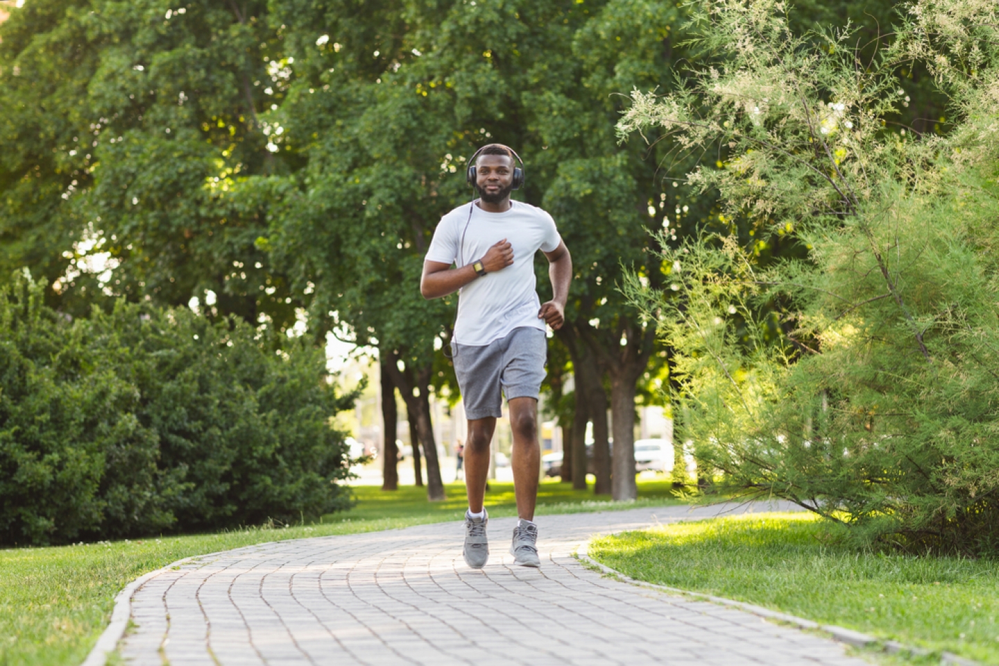 African Athletic Man Jogging In The Park, listening to music