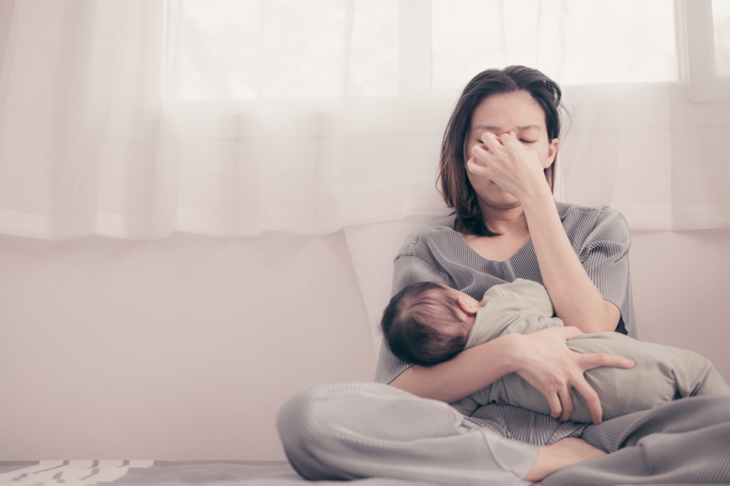 Tired Mother Suffering from experiencing postnatal depression