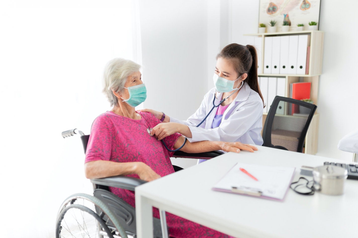 doctor and older patient in wheelchair