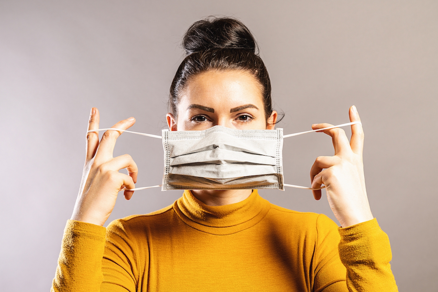 women holds mask over her face