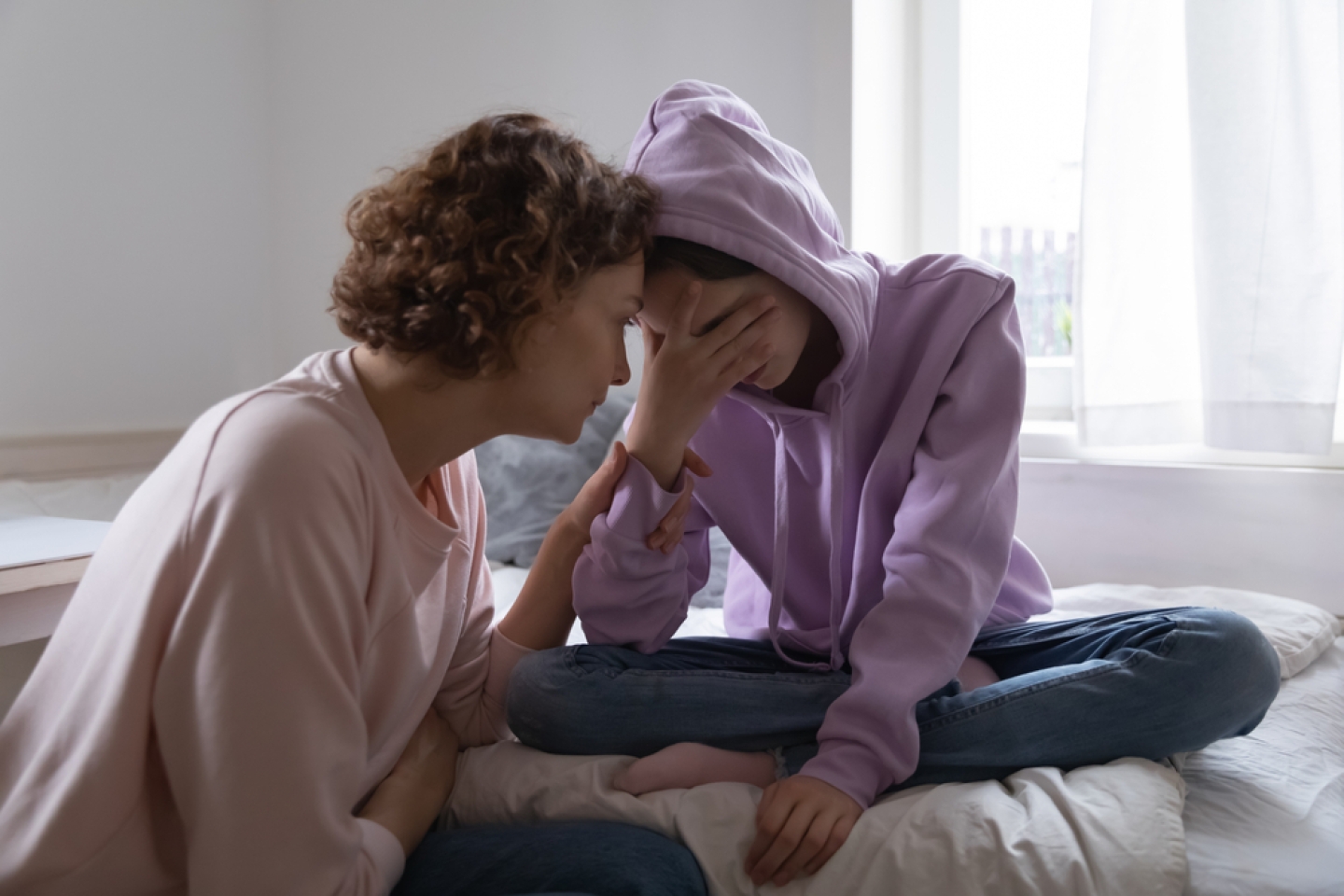 Worried parent young mom comforting depressed crying teen daughter bonding at home.