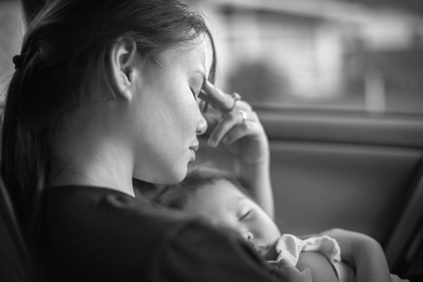 mother holding her baby, tired and stressed.