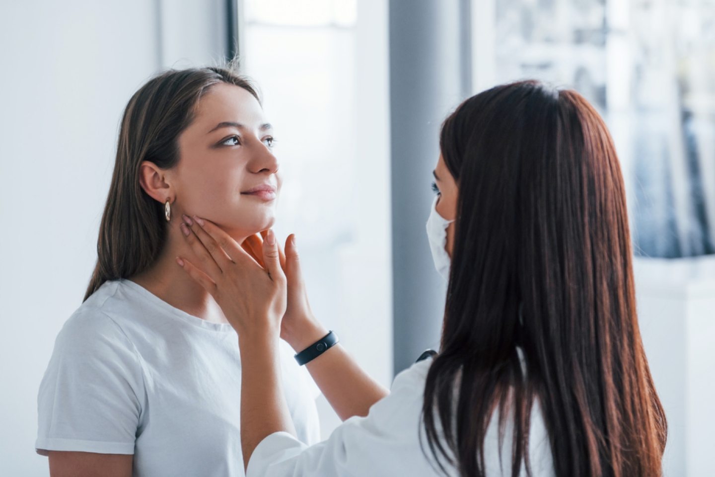 Checking lymph nodes and throat.