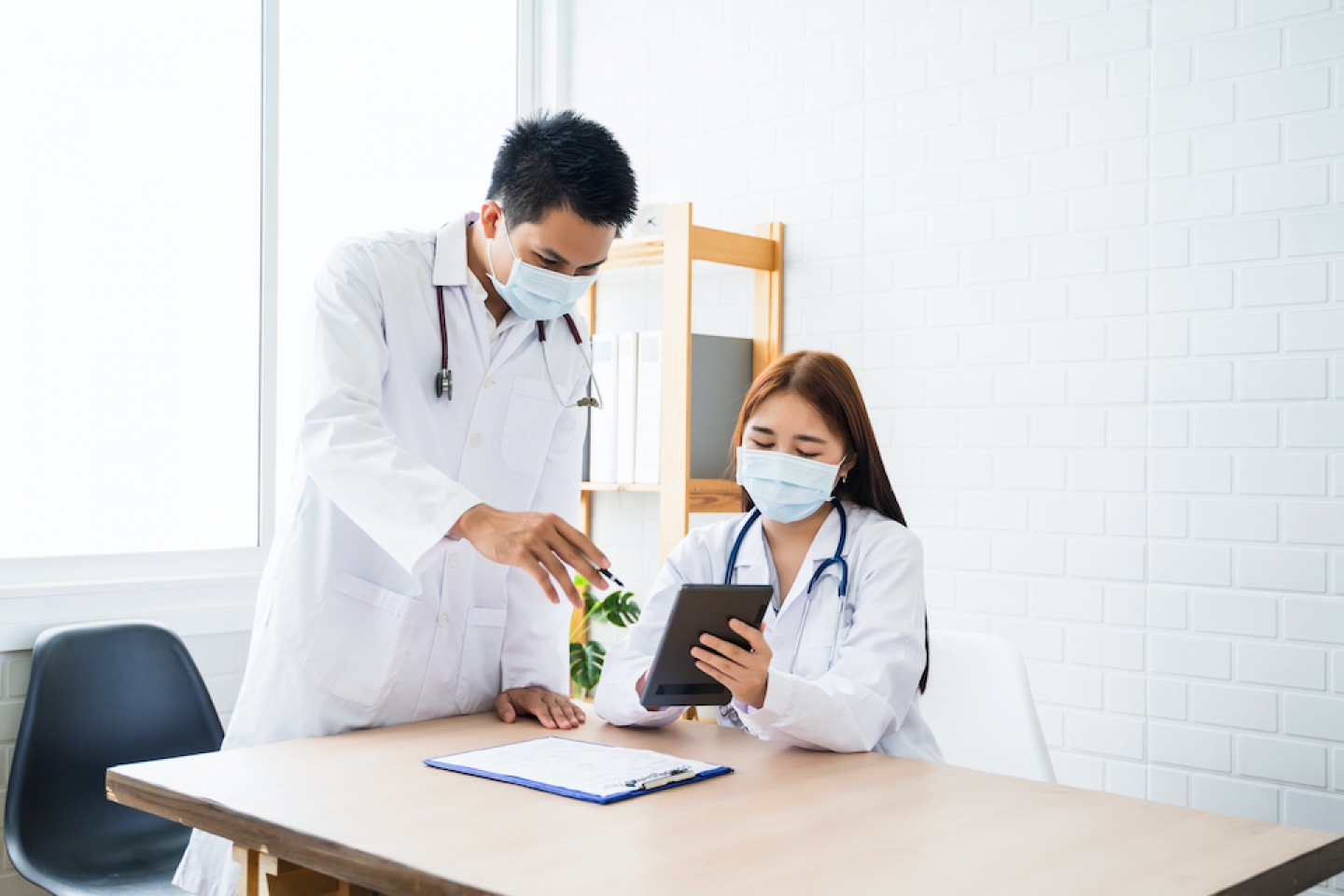 doctors with face masks reviewing charts