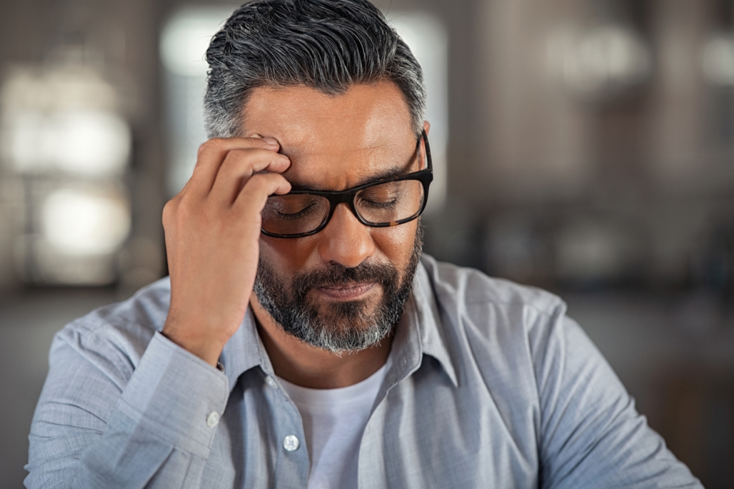 Frustrated middle aged man sitting on couch at home. 