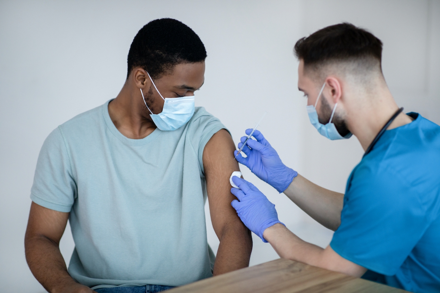 black man getting vaccinated by nurse