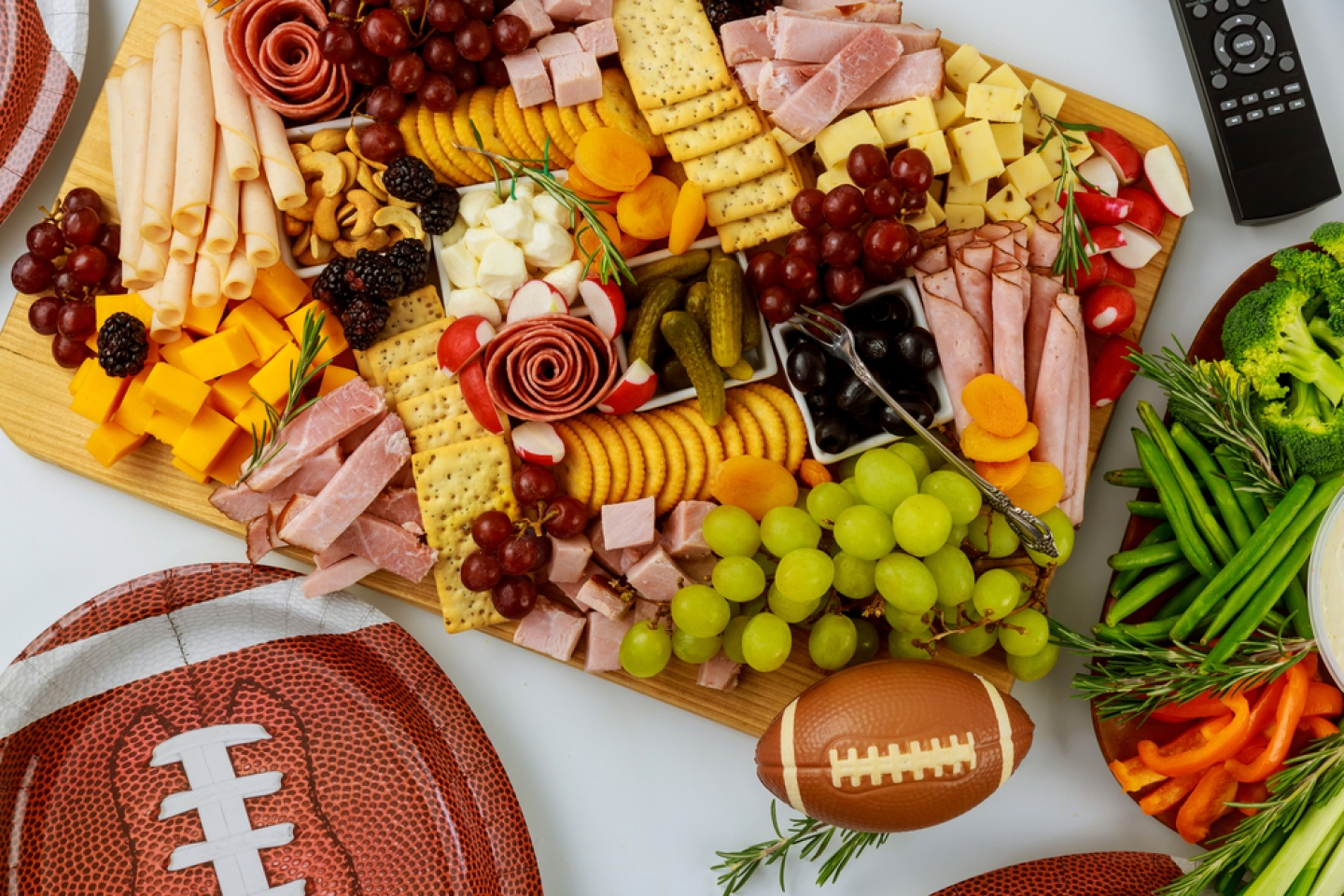 Delicious food for american football game party with remote control for watching sport on tv channel.