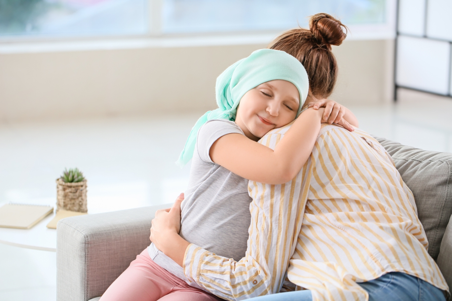 Little girl after chemotherapy with her mother at home