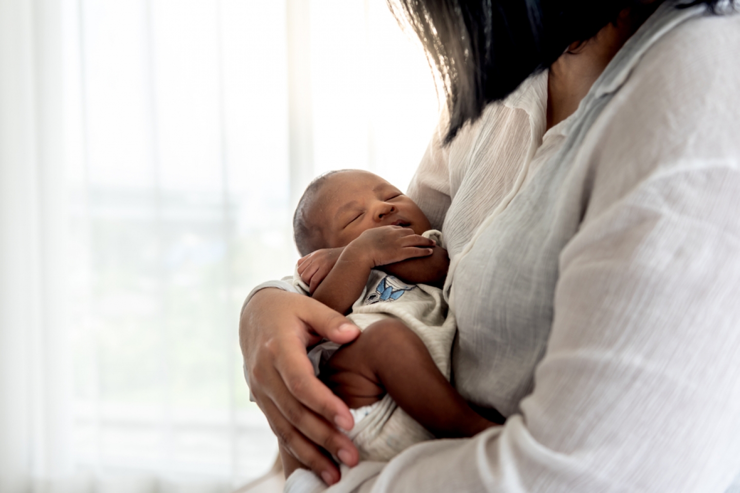 baby newborn son, sleeping with his mother being held,