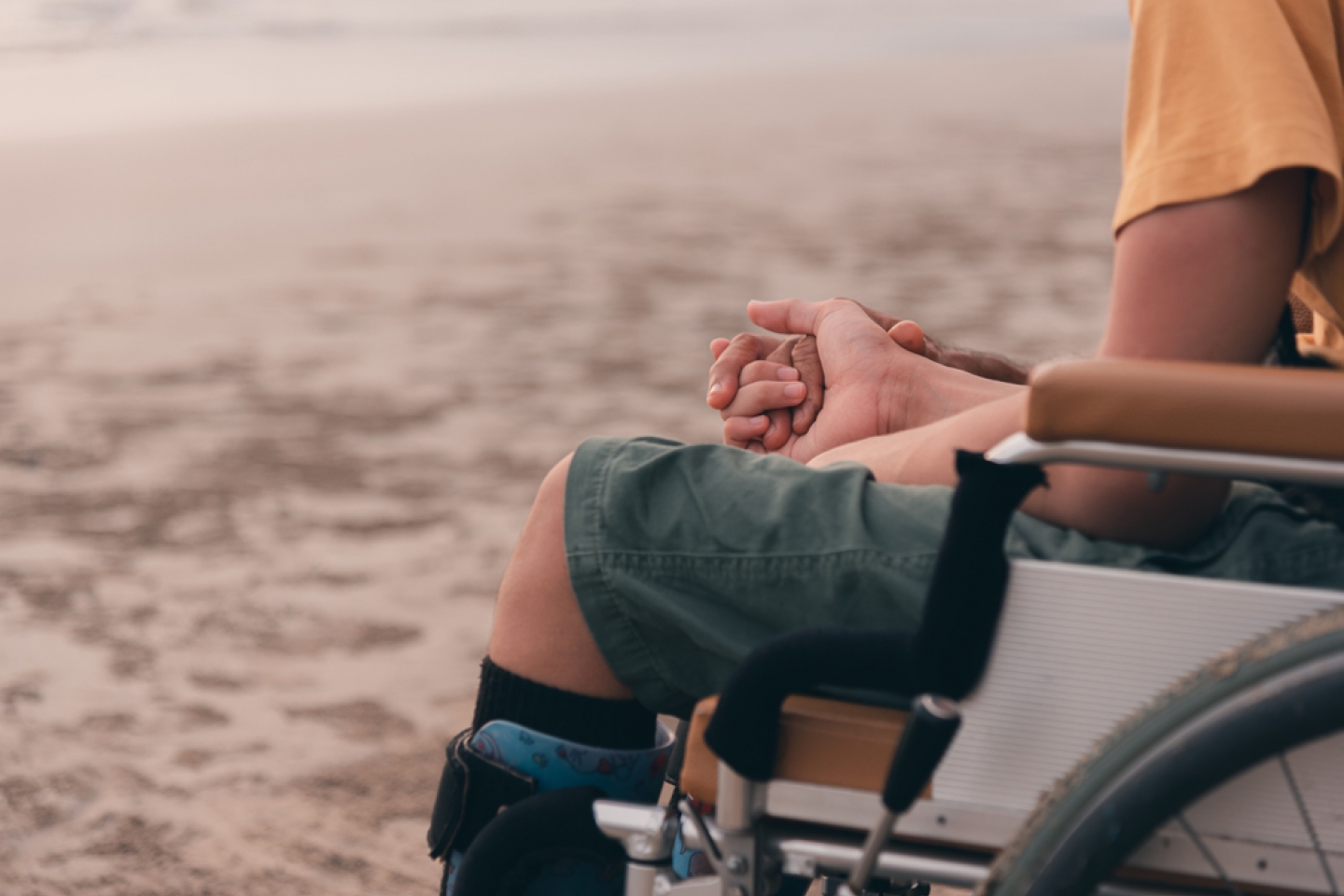 Handicapped children in wheelchairs hold their parents' hands