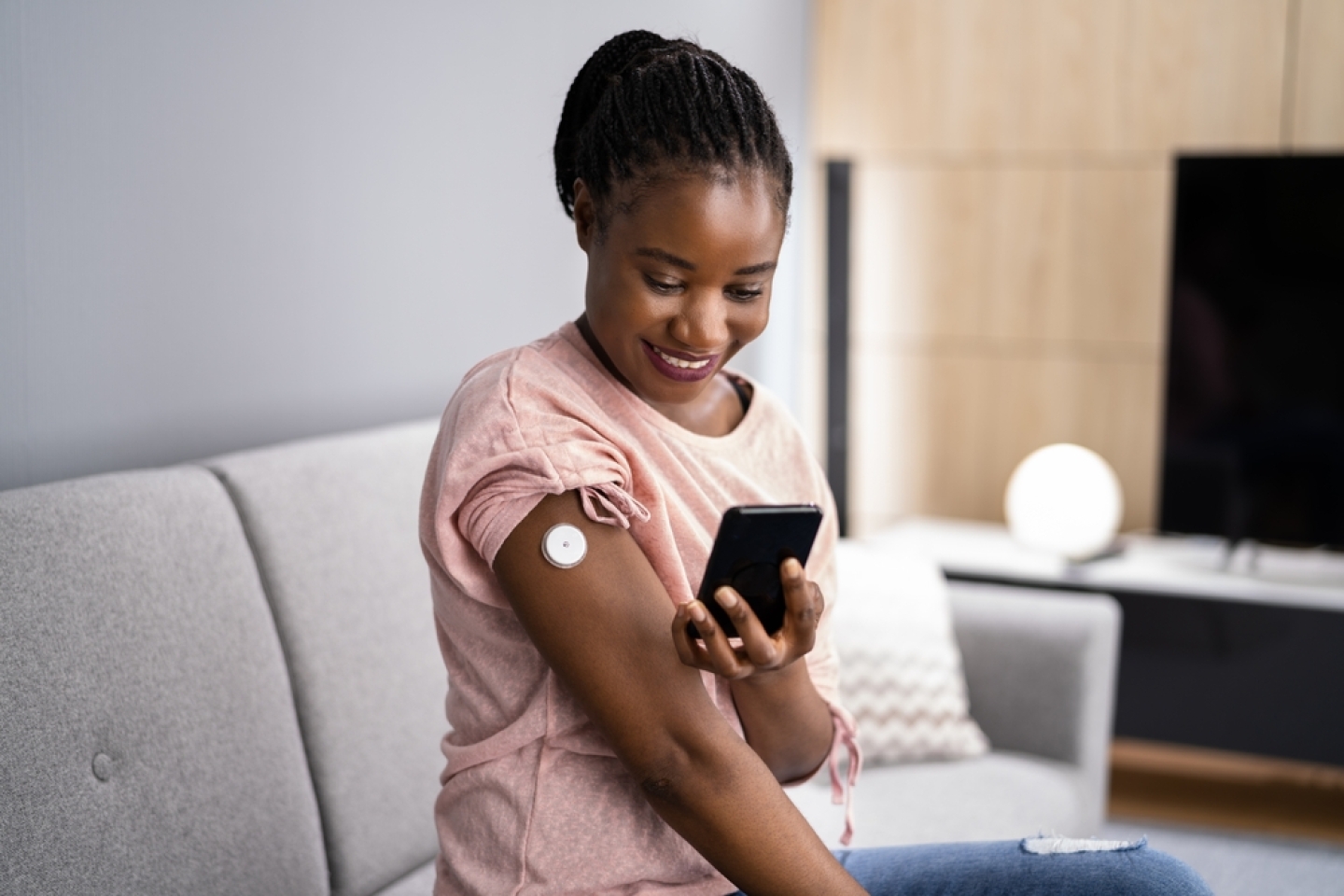 Woman Testing Glucose Level With Continuous Glucose Monitor On Mobile Phone