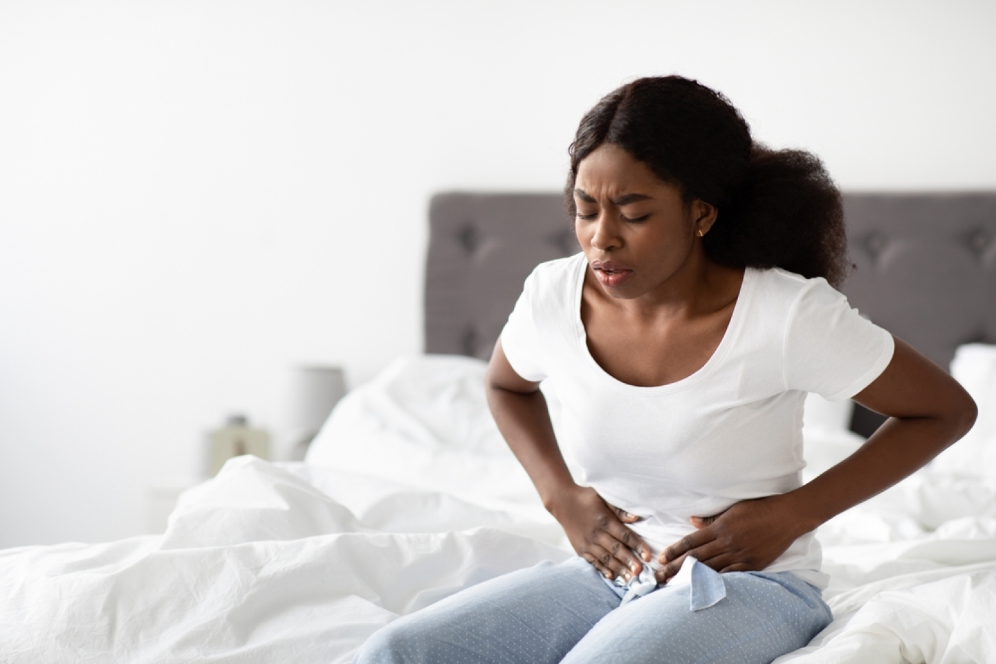 Young african american woman suffering from abdomen pain in the morning