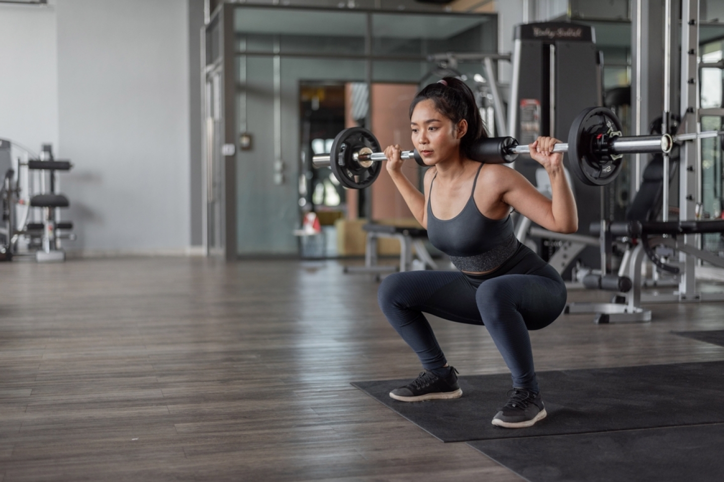 Asian woman exercise in fitness. Young healthy woman in sportswear doing legs exercise in fitness.
