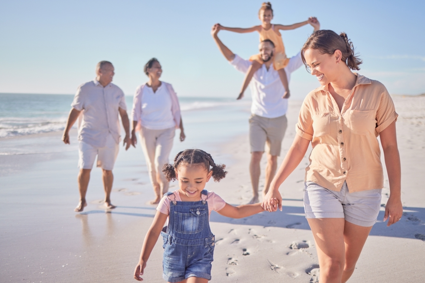  Family, mother and girl holding hands beach on summer holiday.