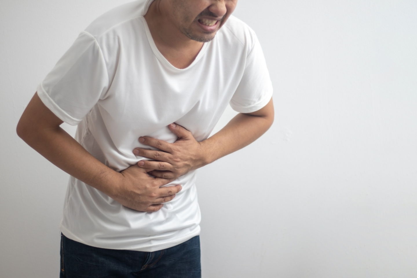 man having abdominal pain on white background