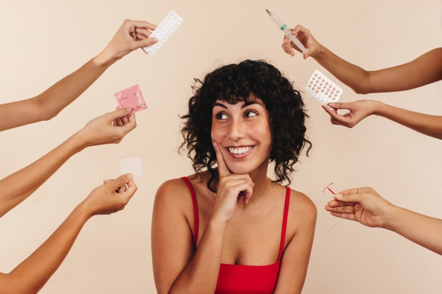 Happy woman in studio with hands offering birth control options.