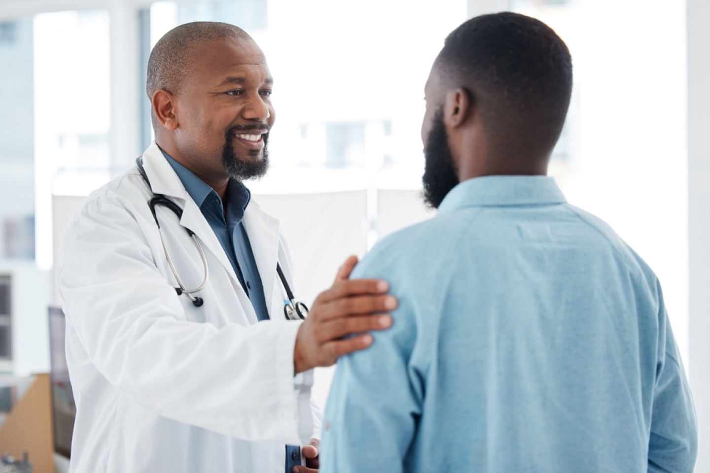 Doctor, black man and touch shoulder of patient for support, comfort and empathy in hospital