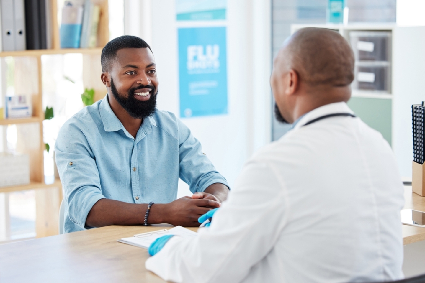 Consulting, patient and happy male with a smile from health communication and expert advice in a clinic