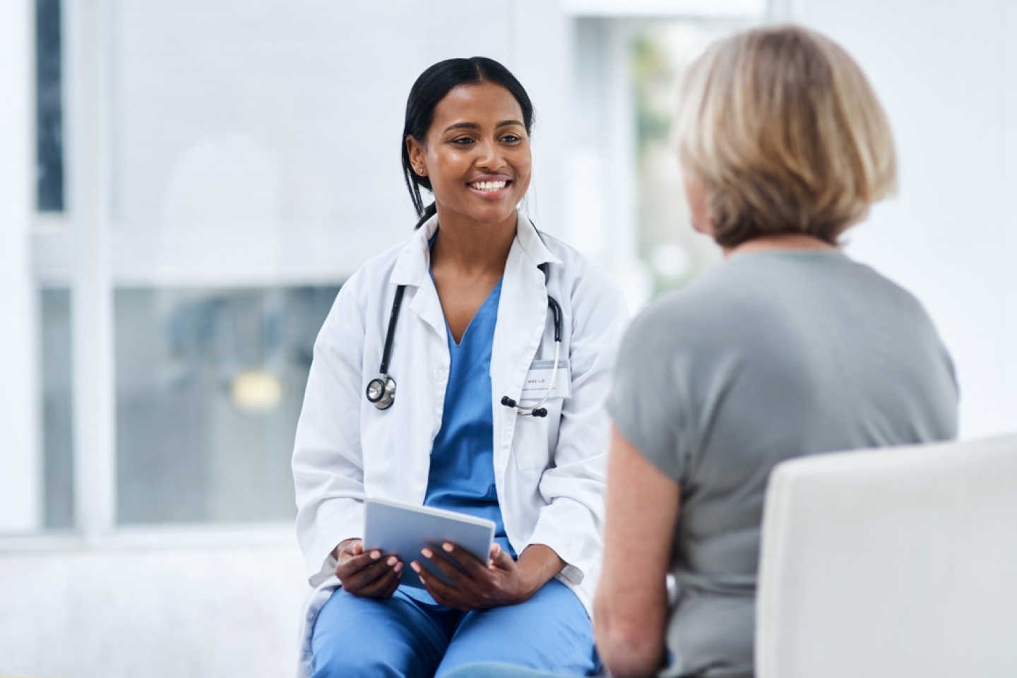 Women, patient and doctor with a tablet, consultation and conversation