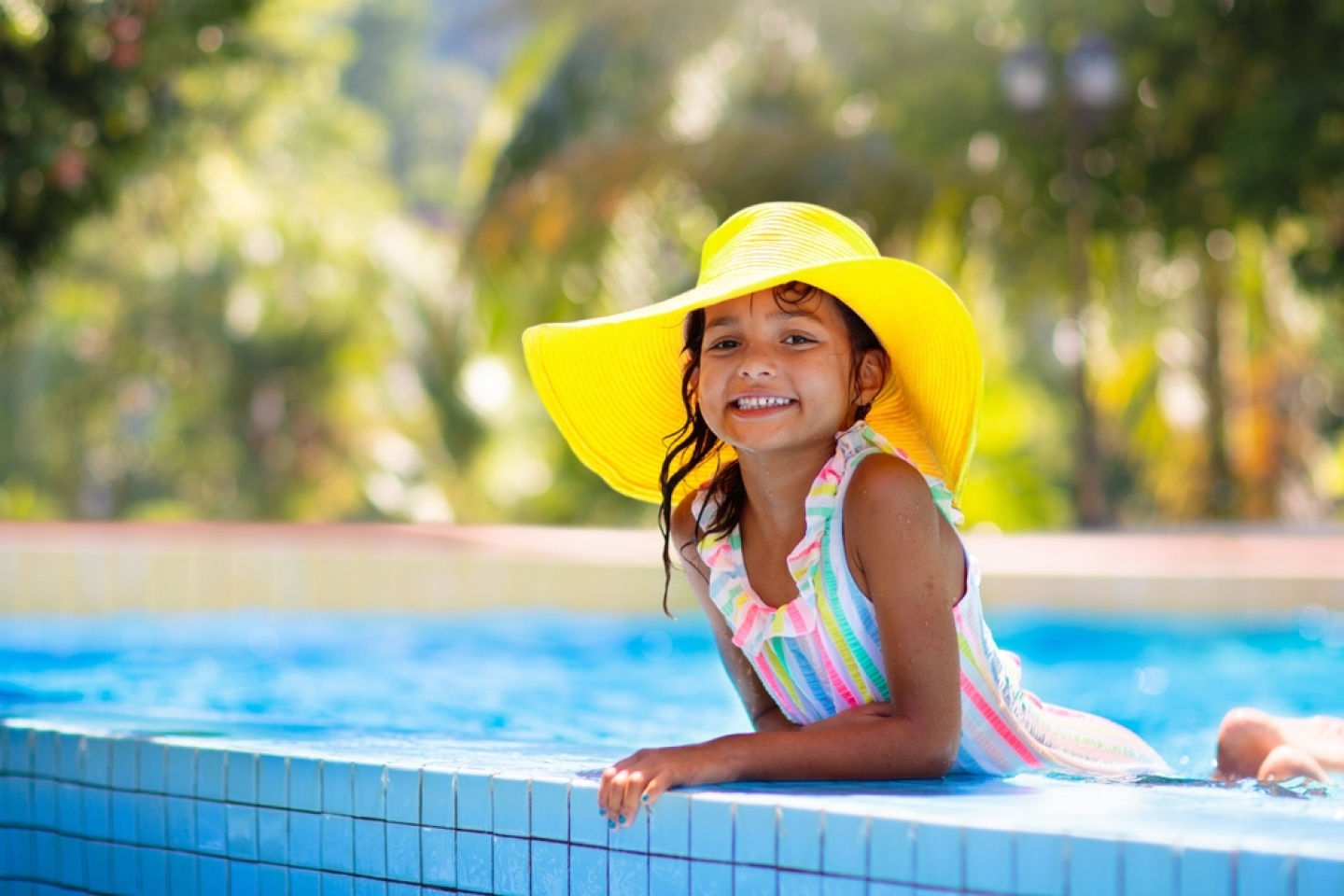 Little girl in swimming pool. Child learning to swim in outdoor pool of tropical resort. Water fun for baby and toddler. Travel with kids. Summer family vacation. Beach holiday with young kid.