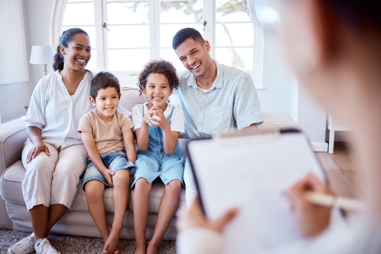 Young kids, mom and dad on couch with psychologist