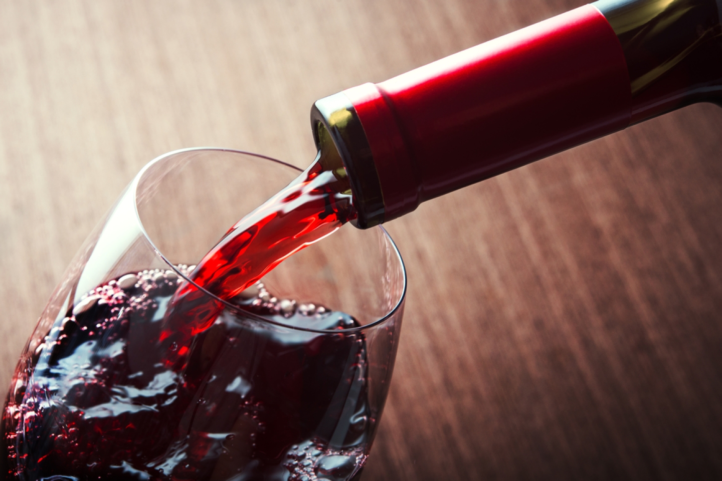 Closeup of red wine pouring in glass