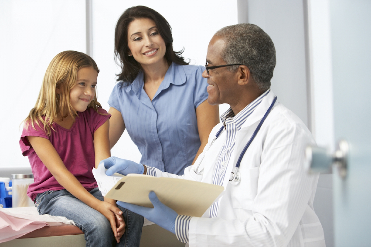 doctor sitting with child and parent